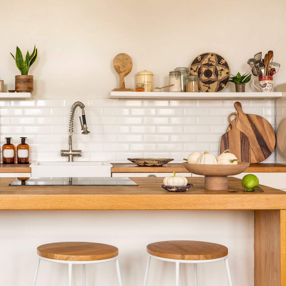 kuchnia w stylu skandynawskim z płytą indukcyjną na wyspie z blatem z jasnego drewna kuchnia w stylu skandynawskim z wyspą z drewnianym blatem i płytą indukcyjną