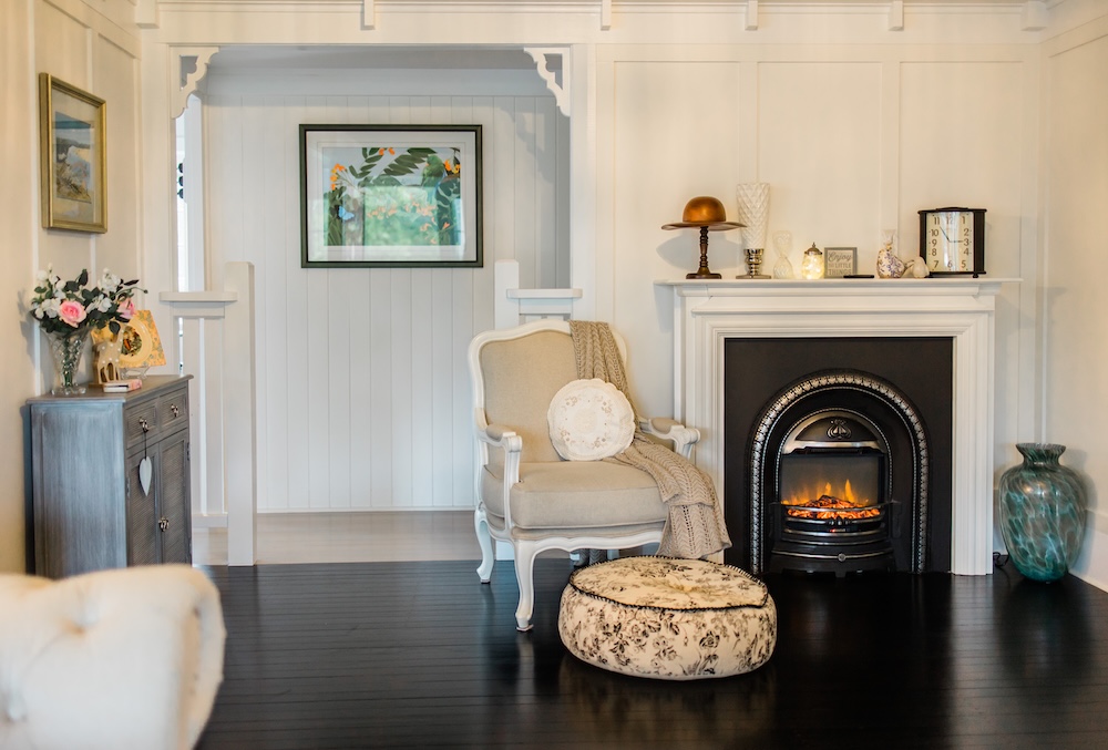 rustykalny styl - pokój farmhouse z fotelem w beżowym kolorze i pufą na czarnej podłodze 