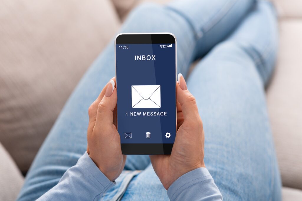  kobieta siedząca z telefonem i otwartą pocztą 
