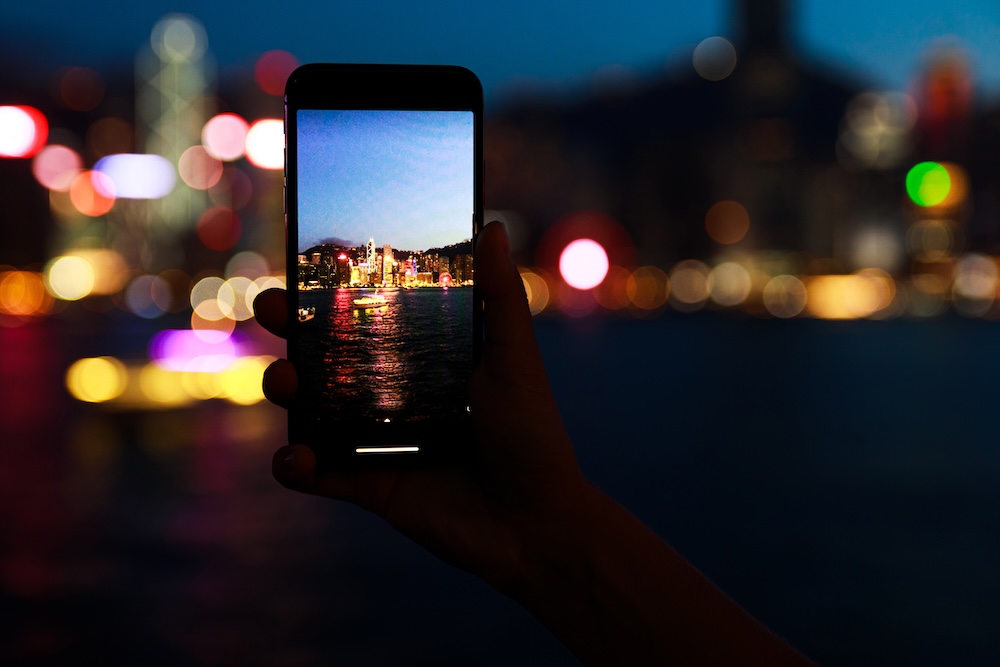 robienie telefonem zdjęcia nocą w mieście 