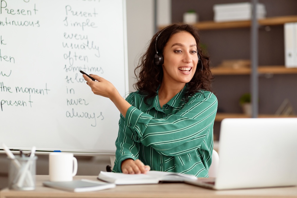 nauczycielka tłumacząca coś na tablicy nauczycielka języka podczas lekcji online
