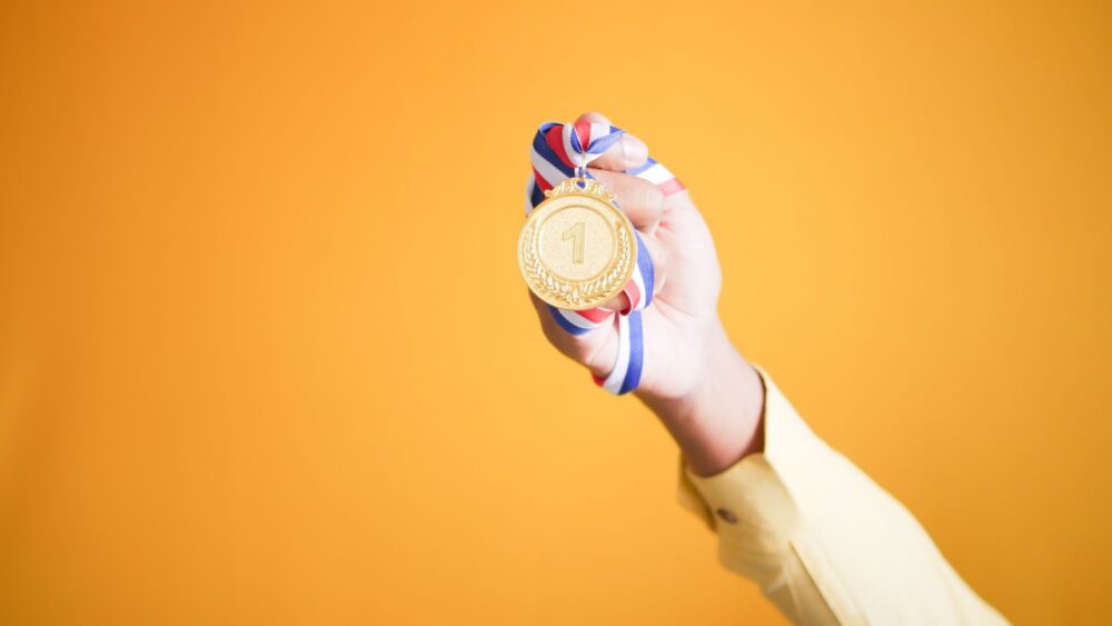 złoty medal w ręce medal trzymany w ręce