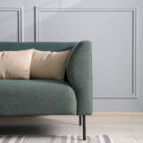 zielona sofa z beżowymi poduszkami w nowoczesnym salonie zielona sofa z beżowymi poduszkami w jasnym salonie